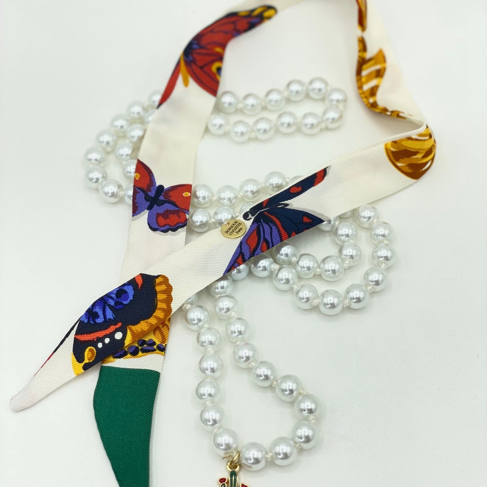 
                  
                    Collier Les Perles de Cocotte avec perles fantaisie et charm cactus, ruban en soie vintage Nina Ricci
                  
                