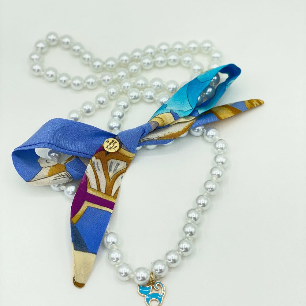 
                  
                    Collier Les Perles de Cocotte avec perles fantaisie et charm chat bleu, ruban en soie vintage Léonard
                  
                